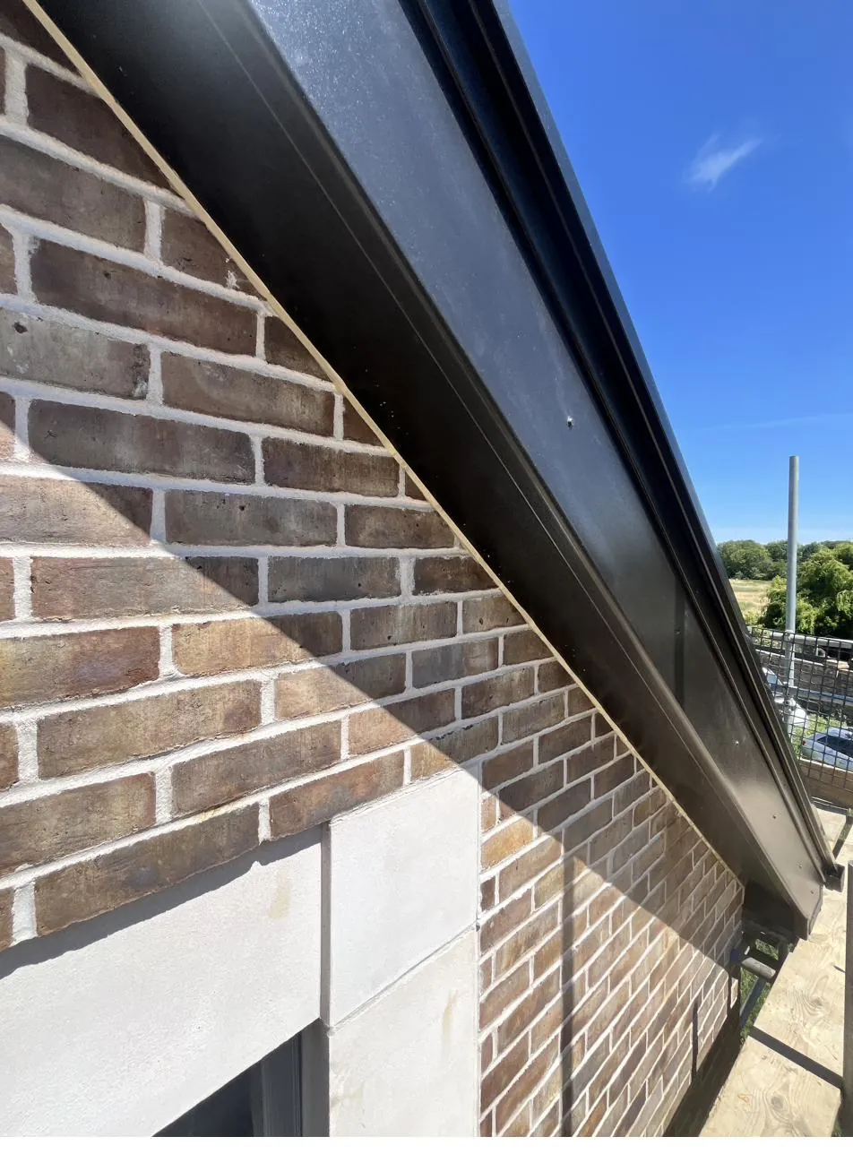 Roofline fascia sealed against brickwork